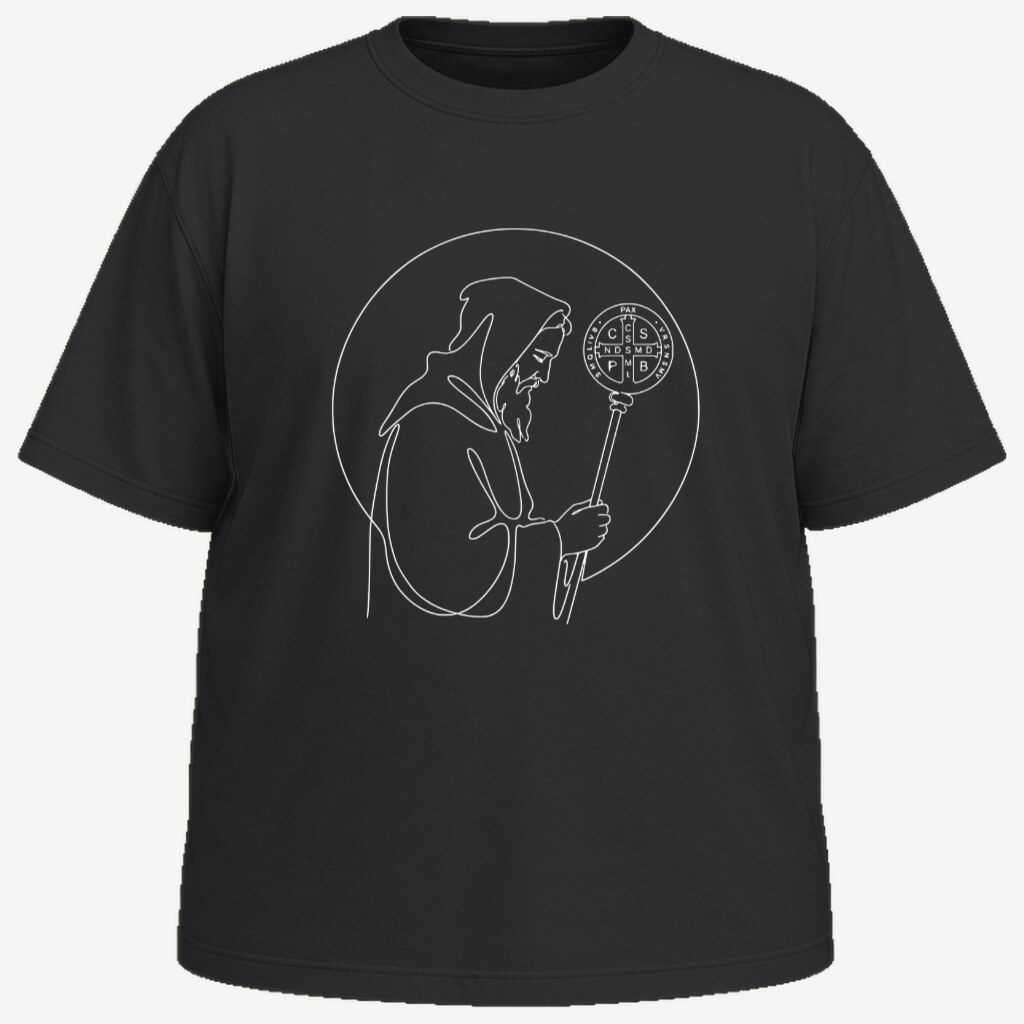 Camiseta preta vista de frente, com São Bento desenhado em branco no peito: figura de perfil, de hábito e capuz, segurando o báculo de abade encimado pela medalha de São Bento — tudo em traço contínuo de uma linha só, dentro de um círculo.
